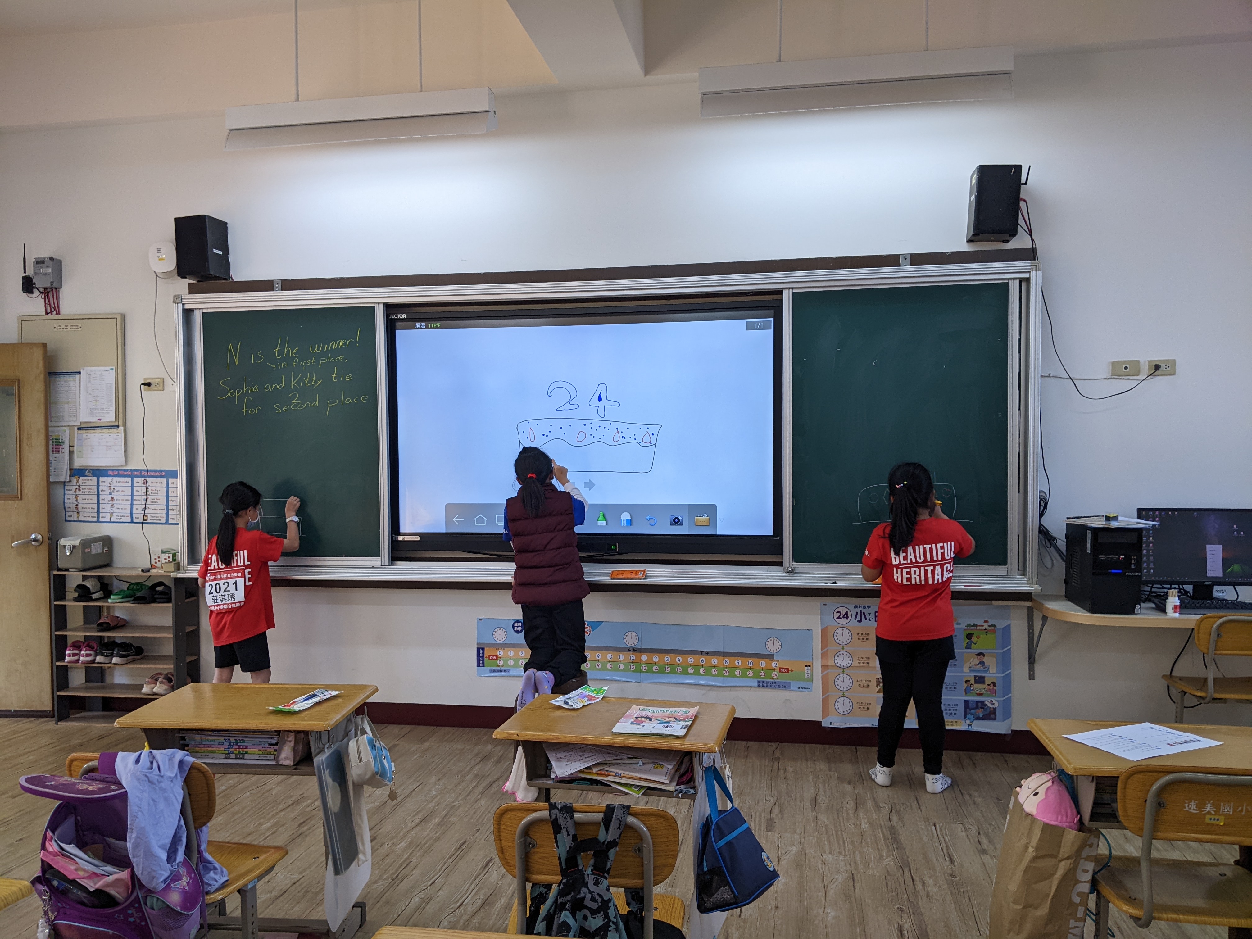 three students, back to, drawing on a blackboard