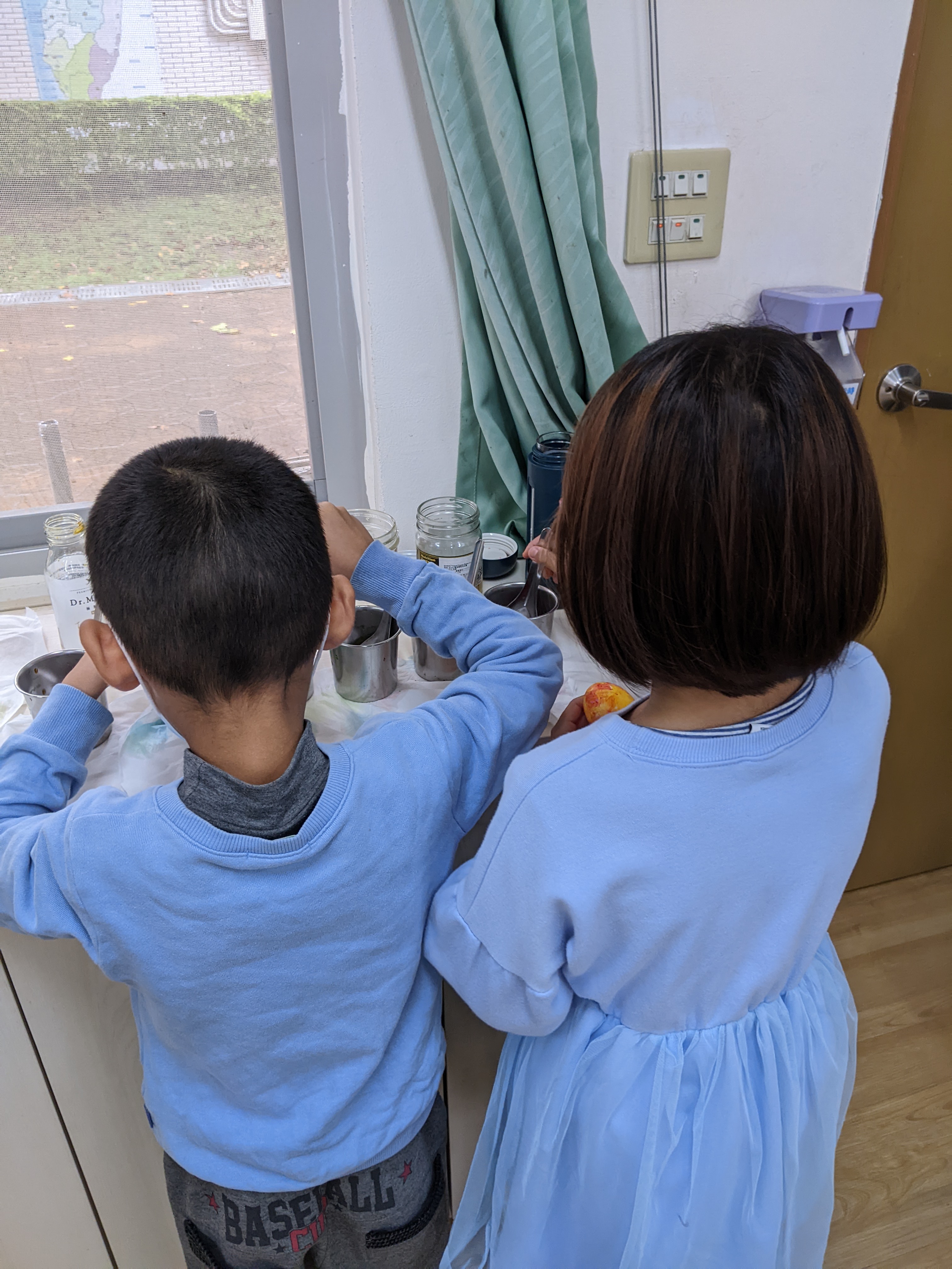 two students faced away from us cooking in a pot