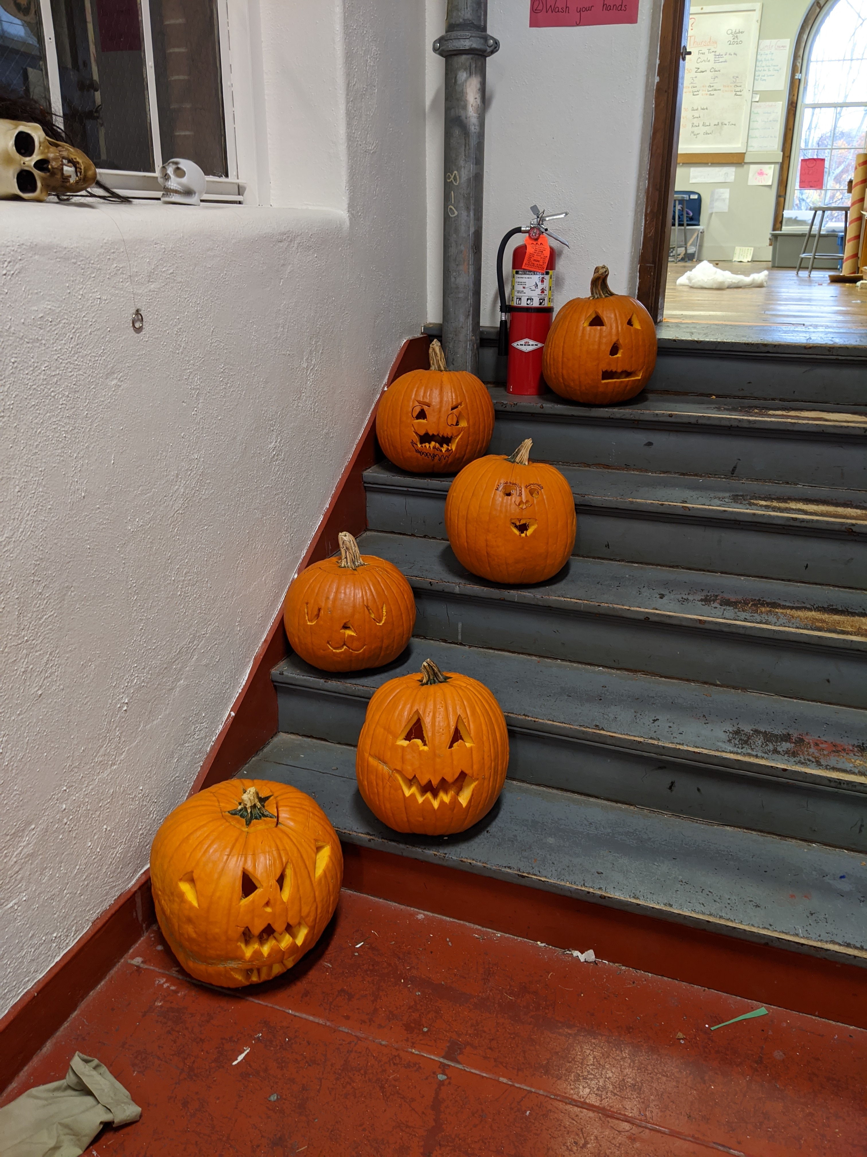 carved large pumpkins on steps in a hallway outside our classroom